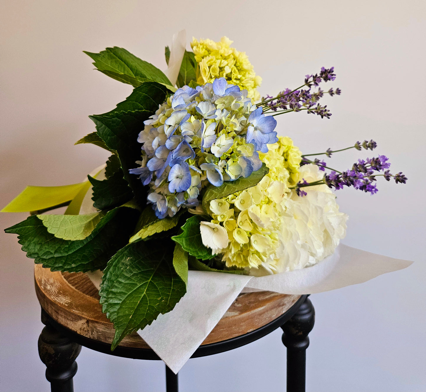 Coastal calm wrapped bouquet, green, white and blue hydrangea accented with lavender blossoms