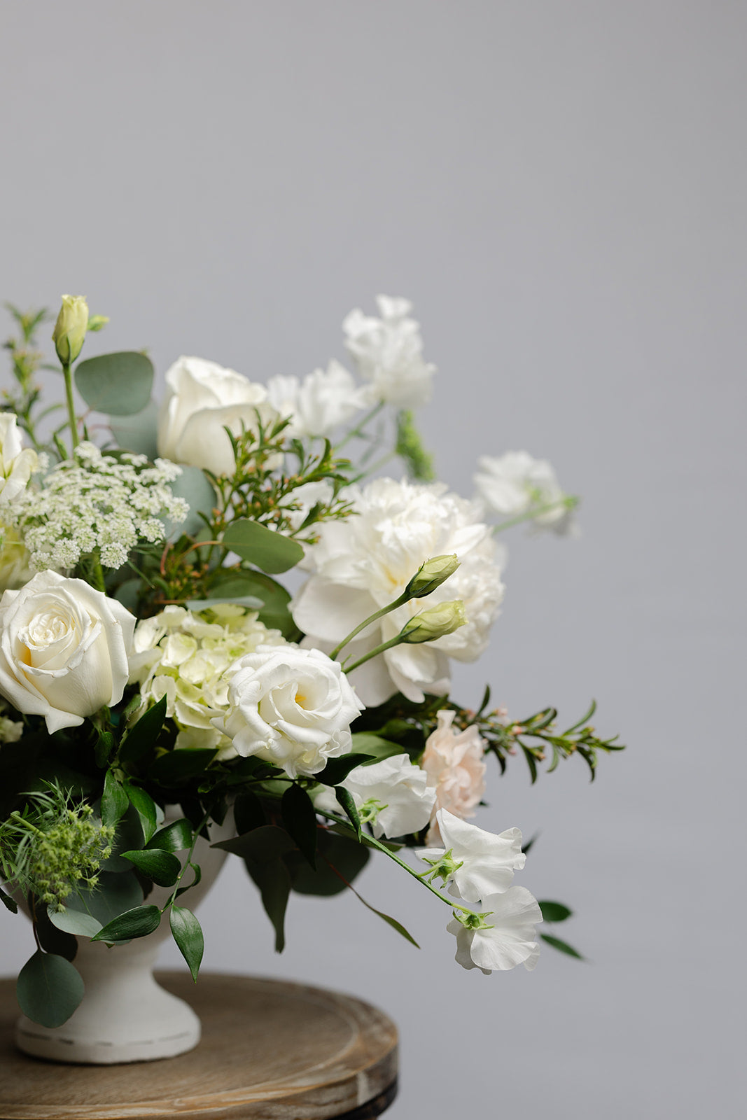 Deluxe wedding centerpiece of white flowers in a footed bowl