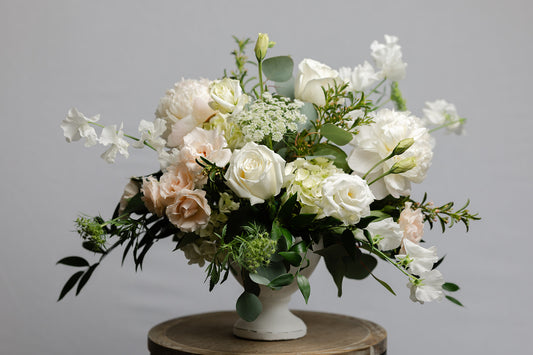 Deluxe wedding centerpiece of white flowers in a footed bowl