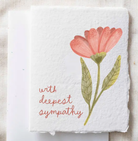 Card with a red flower illustration and 'with deepest sympathy' text on a textured surface.